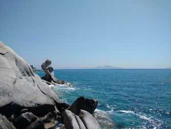 Scenic view of sea and rock formations against clear sky