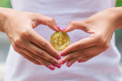 Midsection of woman holding bitcoin