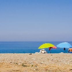 Umbrella on beach against clear sky