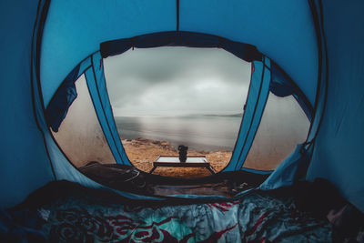 Tent on beach against sky seen through glass