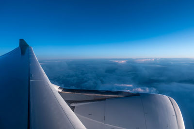 Cropped image of airplane against cloudy blue sky