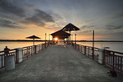 Pier over sea against sky during sunset