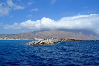 Scenic shot of calm sea against mountain range