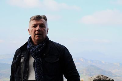 Portrait of mature man standing against sky