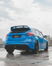 Side view of car on road against blue sky