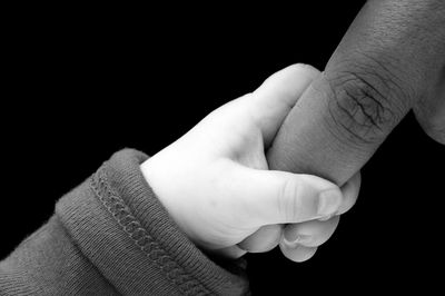 Close-up of human hand against black background