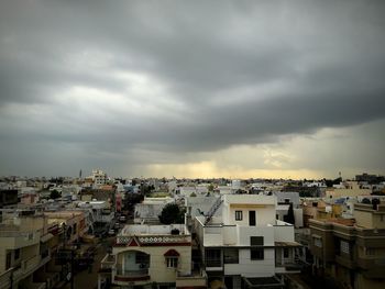 View of cityscape against cloudy sky