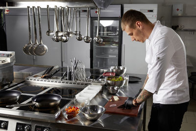 Side view of man preparing food in restaurant