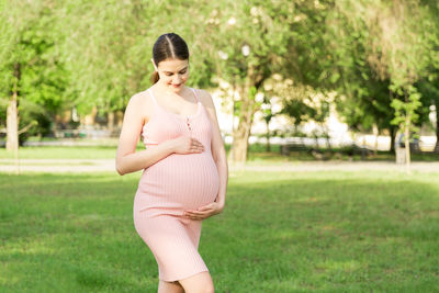 Pregnant woman standing in park