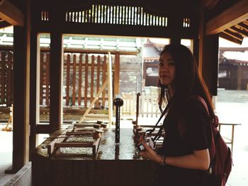 Portrait of young woman standing in corridor