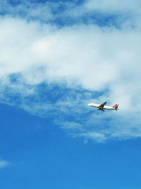 Low angle view of airplane flying against sky