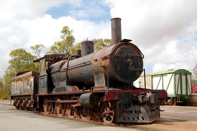 Abandoned train on railroad track against sky