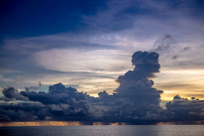 Scenic view of sea against cloudy sky during sunset