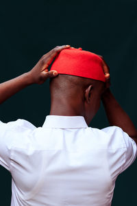 Rear view of man standing against red background