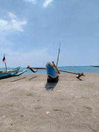 Boats moored at beach against sky