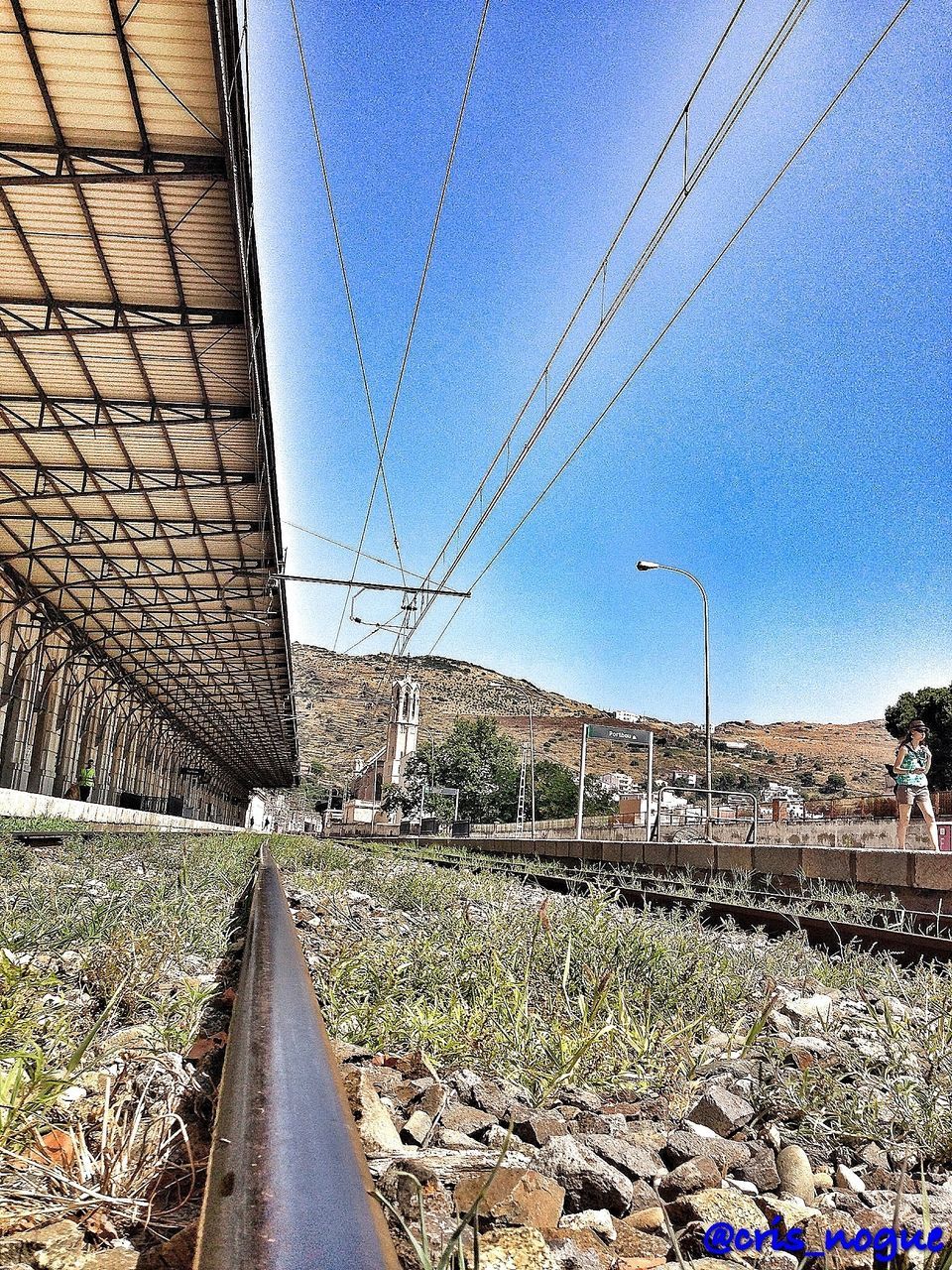 the way forward, railroad track, diminishing perspective, vanishing point, power line, built structure, transportation, architecture, connection, rail transportation, blue, electricity pylon, sky, building exterior, long, cable, day, road, power supply, electricity