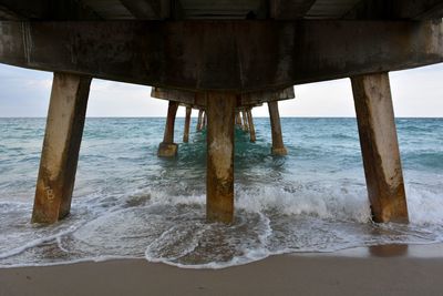 Scenic view of sea against sky from beneath a fishing pier