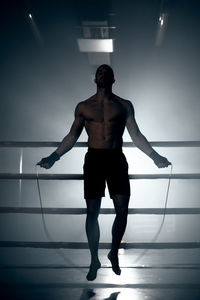 Rear view of shirtless man standing on stage