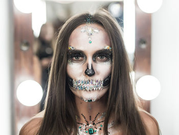 Close-up portrait of young woman with spooky face paint