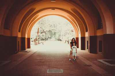 Rear view of women walking in corridor of building