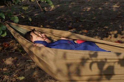 High angle view of woman lying down on hammock