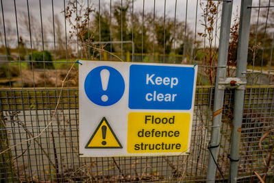 Close-up of warning sign on fence