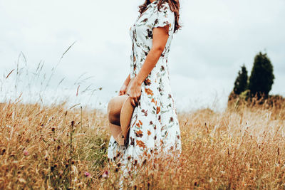 Woman standing on field against sky