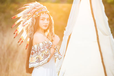 Boho bohemian girl styled wearing indian maxi dress and jewellery in autumn field