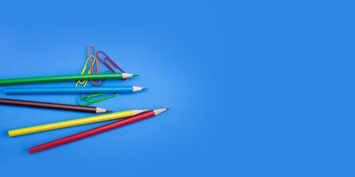 High angle view of colored pencils against blue background