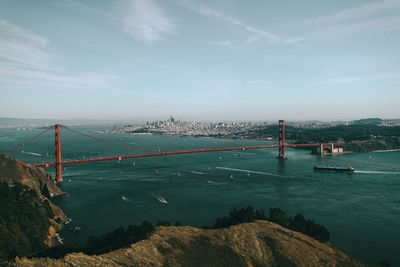 Suspension bridge over sea against sky