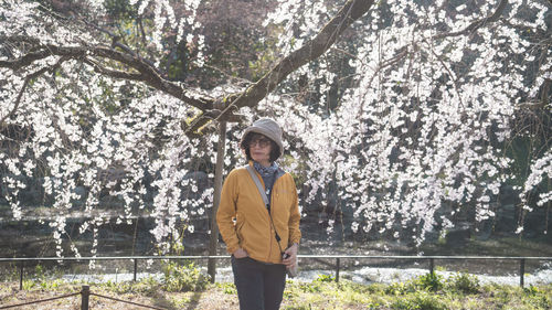 Portrait of woman standing against trees