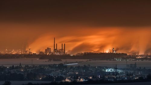 View of illuminated factory against sky