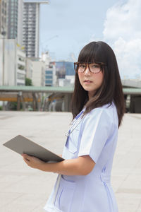 Young female doctor standing in city