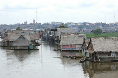 Buildings by river against sky in city