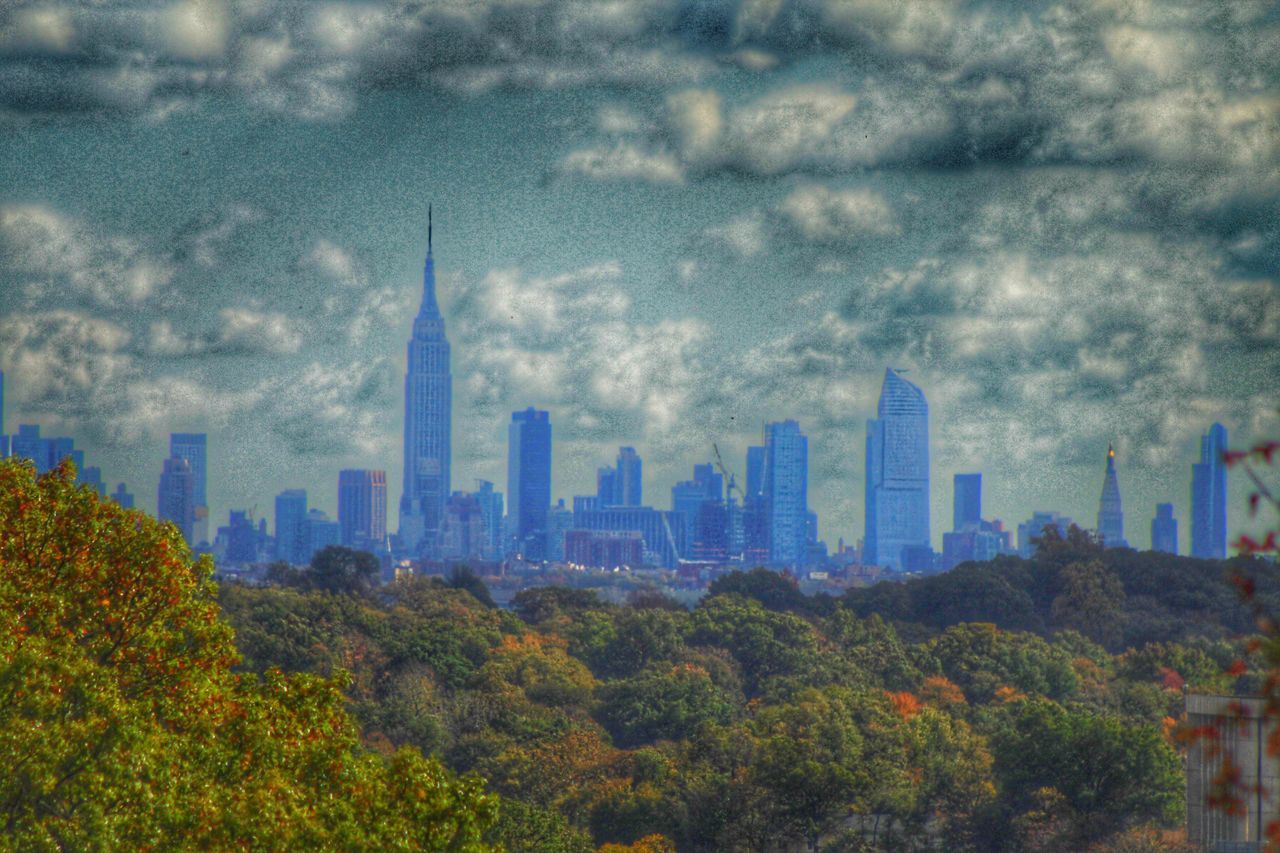 tree, architecture, city, built structure, building exterior, travel destinations, skyscraper, sky, tourism, tower, urban skyline, tall - high, cityscape, city life, international landmark, cloud - sky, famous place, growth, modern, outdoors, office building, capital cities, lush foliage, financial district