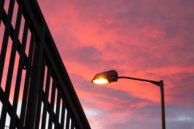 Low angle view of illuminated street light against orange sky