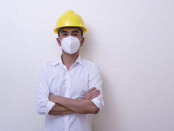 Man wearing hat standing against white background