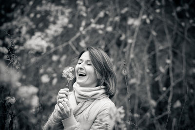 Portrait of smiling young woman standing on land