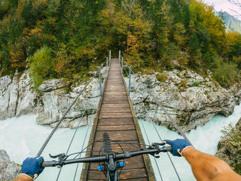 Gopro first person view mountain biking on  wooden suspension bridge above soca river, slovenia.