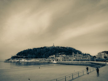 Buildings by sea against sky in city