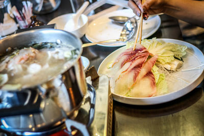 Close-up of person preparing food on table