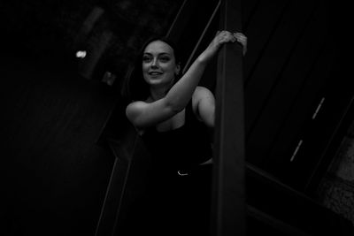 Portrait of young woman holding camera in the dark