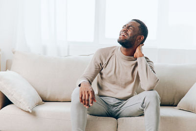 Senior man sitting on sofa at home