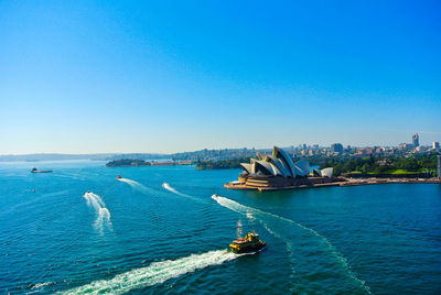 High angle view of cruise next to opera house against clear sky
