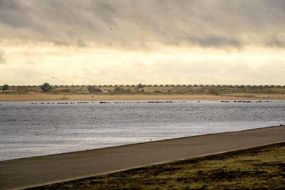 Scenic view of beach against sky during sunset