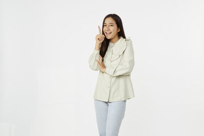 Portrait of smiling young woman against white background