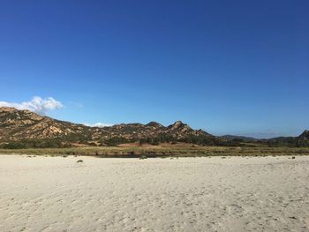 Scenic view of desert against clear blue sky