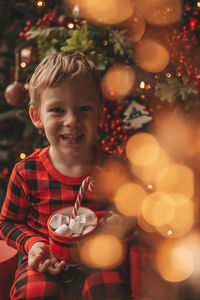 Portrait of cute girl decorating christmas tree at night