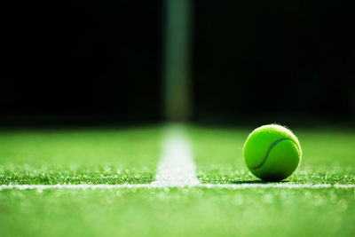 Close-up of tennis ball on field in court