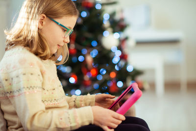Girl using digital tablet at home during christmas